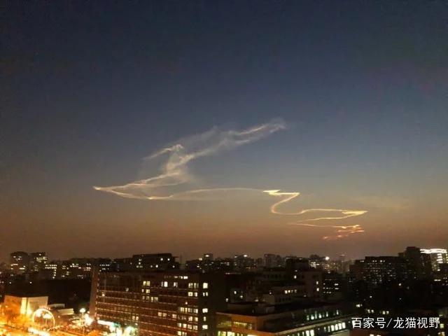 许多人亲眼目睹到了神奇的"天降祥云":蜿蜒的白色烟迹划过傍晚的天空